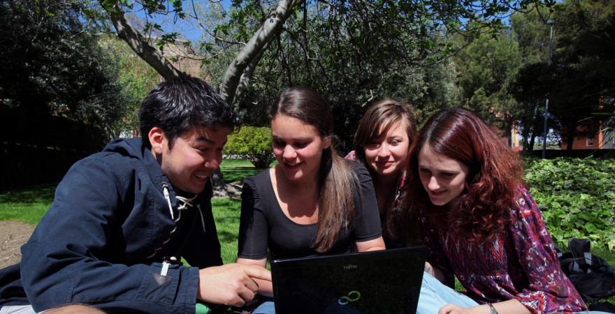 Alumnado de la UJA, consultando un portátil en el campus de Jaén.