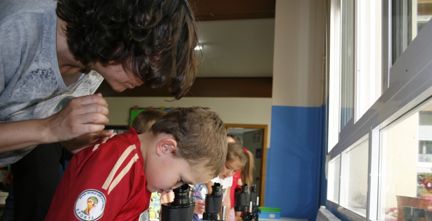 Un alumno mira por el microscopio.