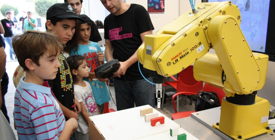 Javier Gámez muestra el funcionamiento de un autómata a unos niños.
