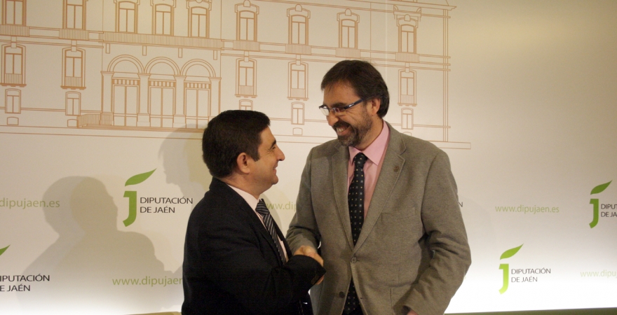 Francisco Reyes y Juan Gómez se estrechan la mano, tras la firma del convenio