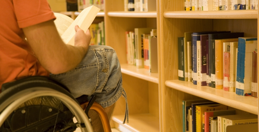Un estudiante en silla de ruedas, en la biblioteca de la UJA.