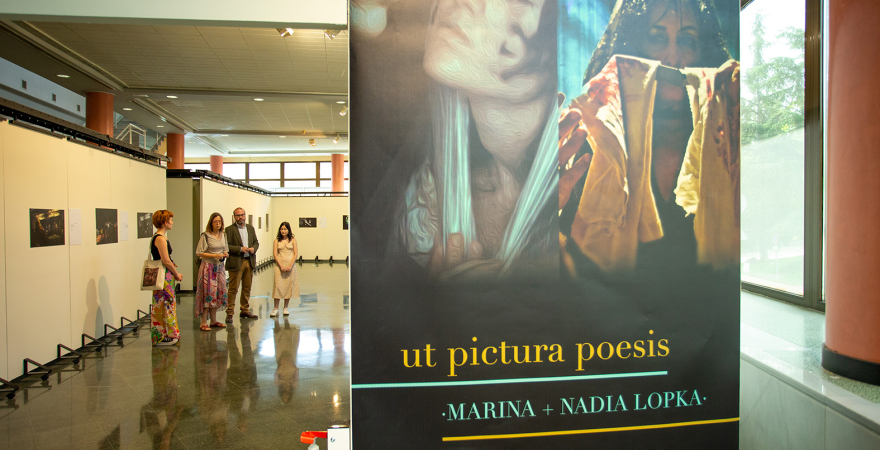 Un momento de la inauguración de la exposición, con su cartel en primer plano.