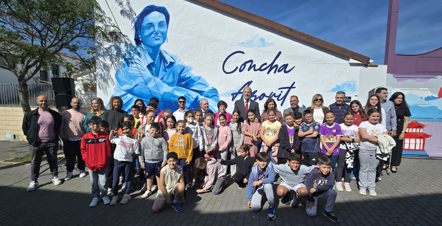 Representantes institucionales y escolares, delante del mural dedicado a Concha Azorit.