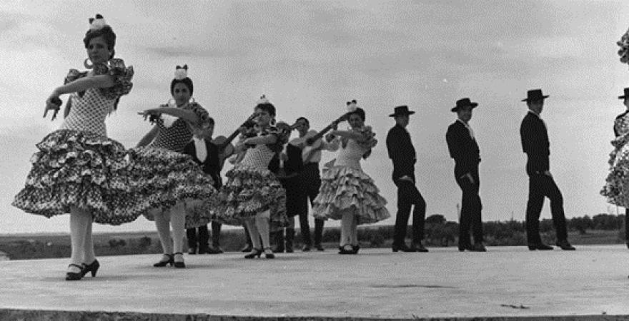 Escenario con danzantes gaditanos bailando sevillanas, posiblemente durante la celebración del XVII Concurso de Coros y Danzas de la Sección Femenina.