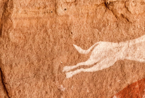 Una cazador con dos perros, representados en las cuevas rupestres de Tadrart Acacus (Libia). Giampaolo Cianella/Shutterstock.
