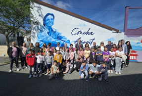 Representantes institucionales y escolares, delante del mural dedicado a Concha Azorit.