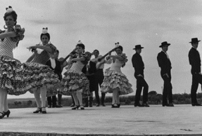 Escenario con danzantes gaditanos bailando sevillanas, posiblemente durante la celebración del XVII Concurso de Coros y Danzas de la Sección Femenina.