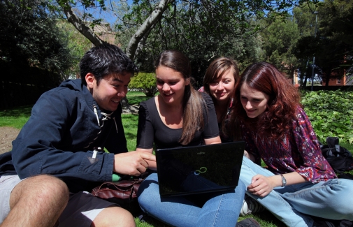 Alumnado de la UJA, consultando un portátil en el campus de Jaén.