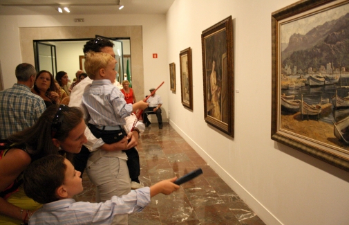 Una familia admira la obra del pintor Alfonso Parras