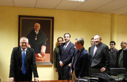 Manuel Parras posa junto a su retrato, ante la mirada del Rector Juan Gómez y responsables de universidades andaluzas