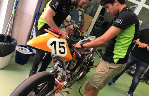 Miembros del equipo EPS Jaén-UJA Team trabajan con la moto.
