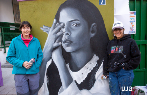 Las dos artistas posan ante el retrato de Ángeles Toledano. Fotografía: Fernando Mármol.