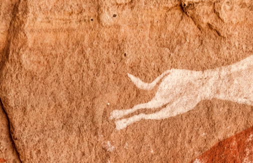 Una cazador con dos perros, representados en las cuevas rupestres de Tadrart Acacus (Libia). Giampaolo Cianella/Shutterstock.