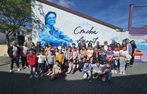 Representantes institucionales y escolares, delante del mural dedicado a Concha Azorit.